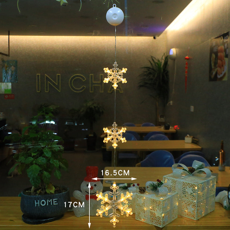 Three warm-white Christmas pendants glowing in window