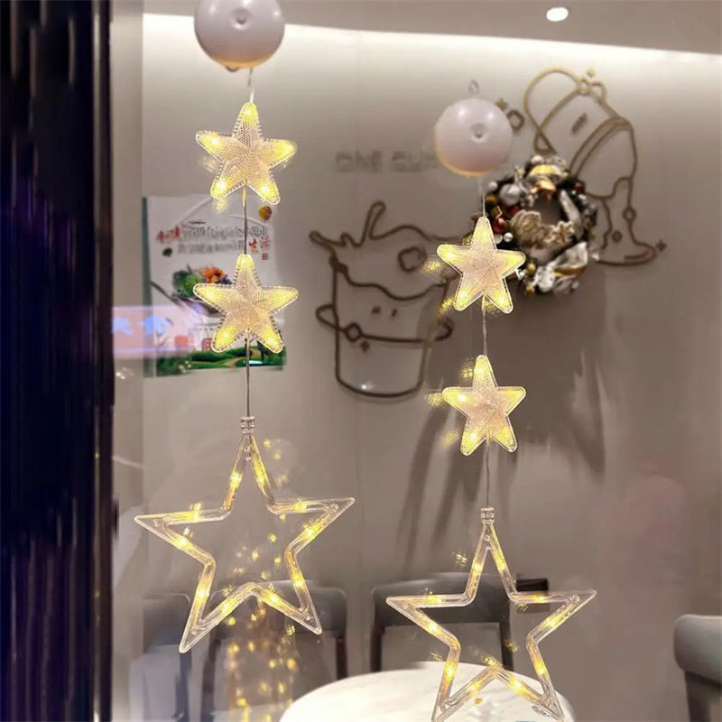 Three warm-white Christmas pendants glowing in window