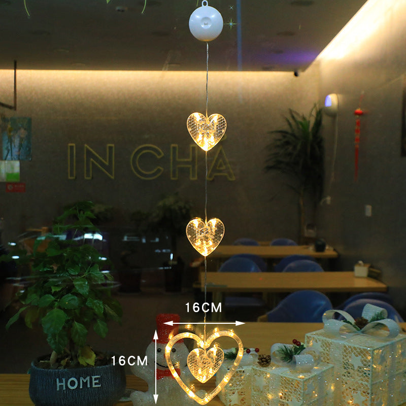 Three warm-white Christmas pendants glowing in window