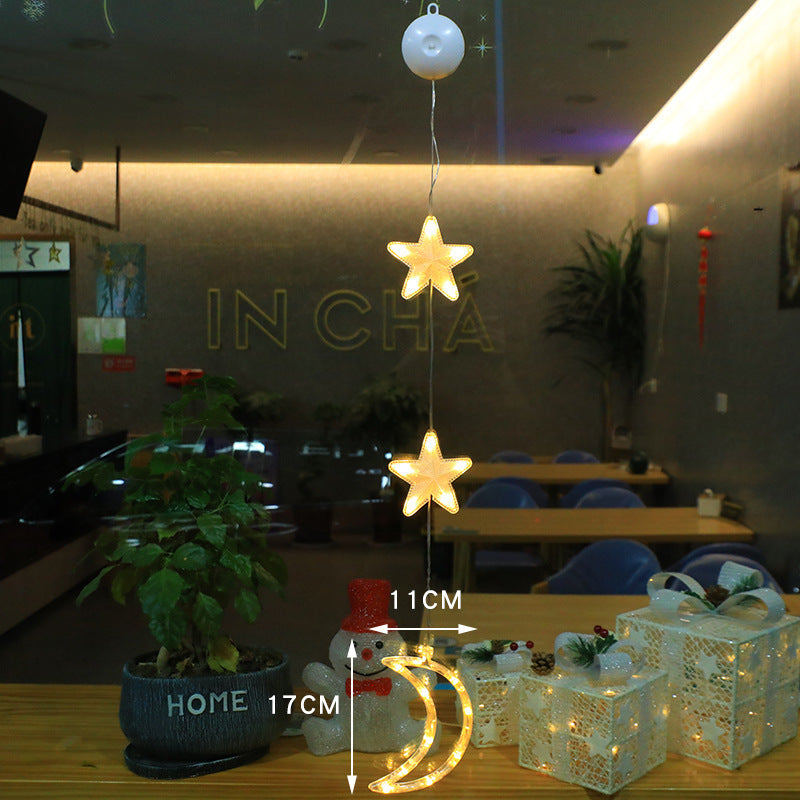 Three warm-white Christmas pendants glowing in window