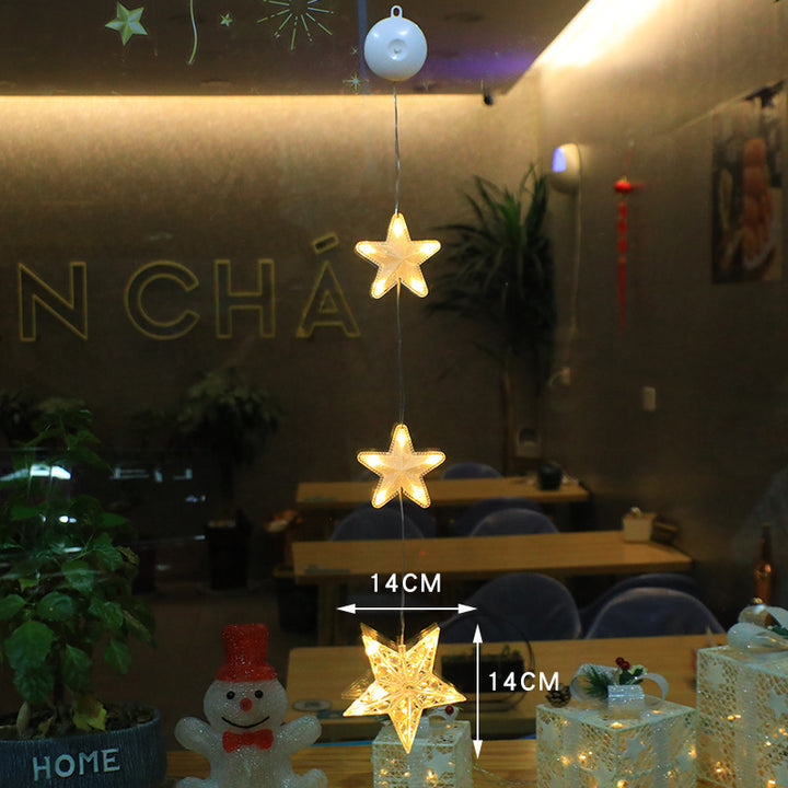 Three warm-white Christmas pendants glowing in window