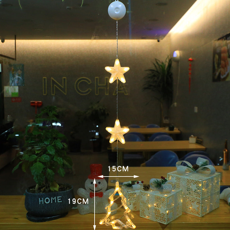 Three warm-white Christmas pendants glowing in window