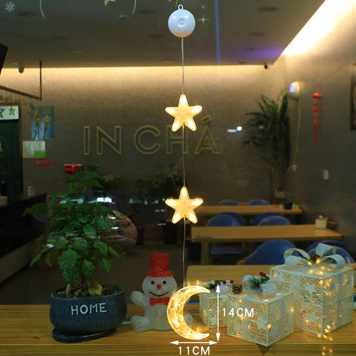 Three warm-white Christmas pendants glowing in window