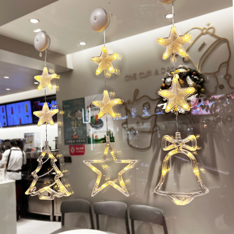 Three warm-white Christmas pendants glowing in window