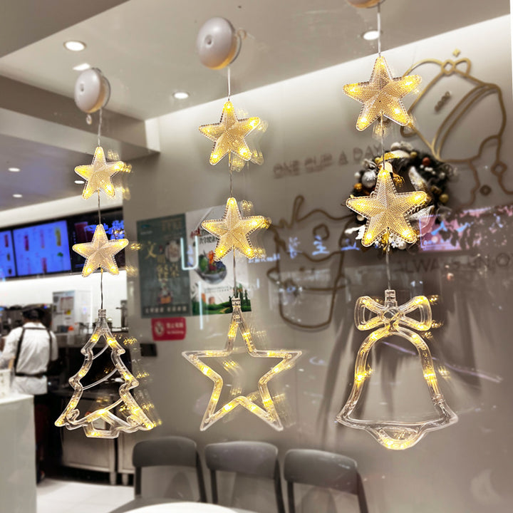 Three warm-white Christmas pendants glowing in window