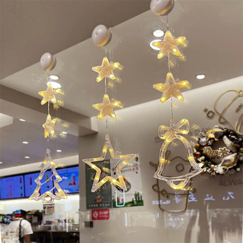 Three warm-white Christmas pendants glowing in window