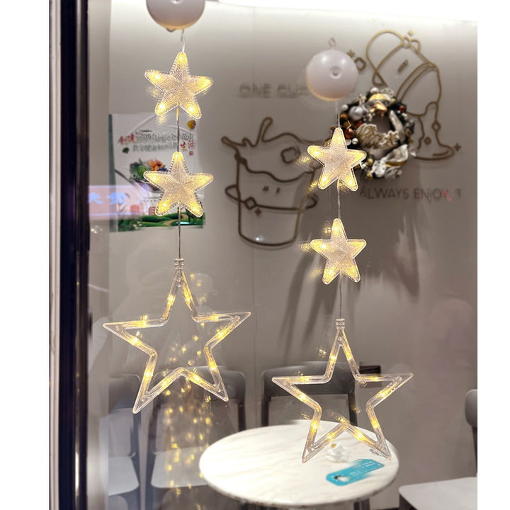 Three warm-white Christmas pendants glowing in window
